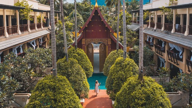 A resort with a central courtyard, palm trees, and a traditional structure with a pointed roof. - Burasari Phuket Resort & Spa (Patong)