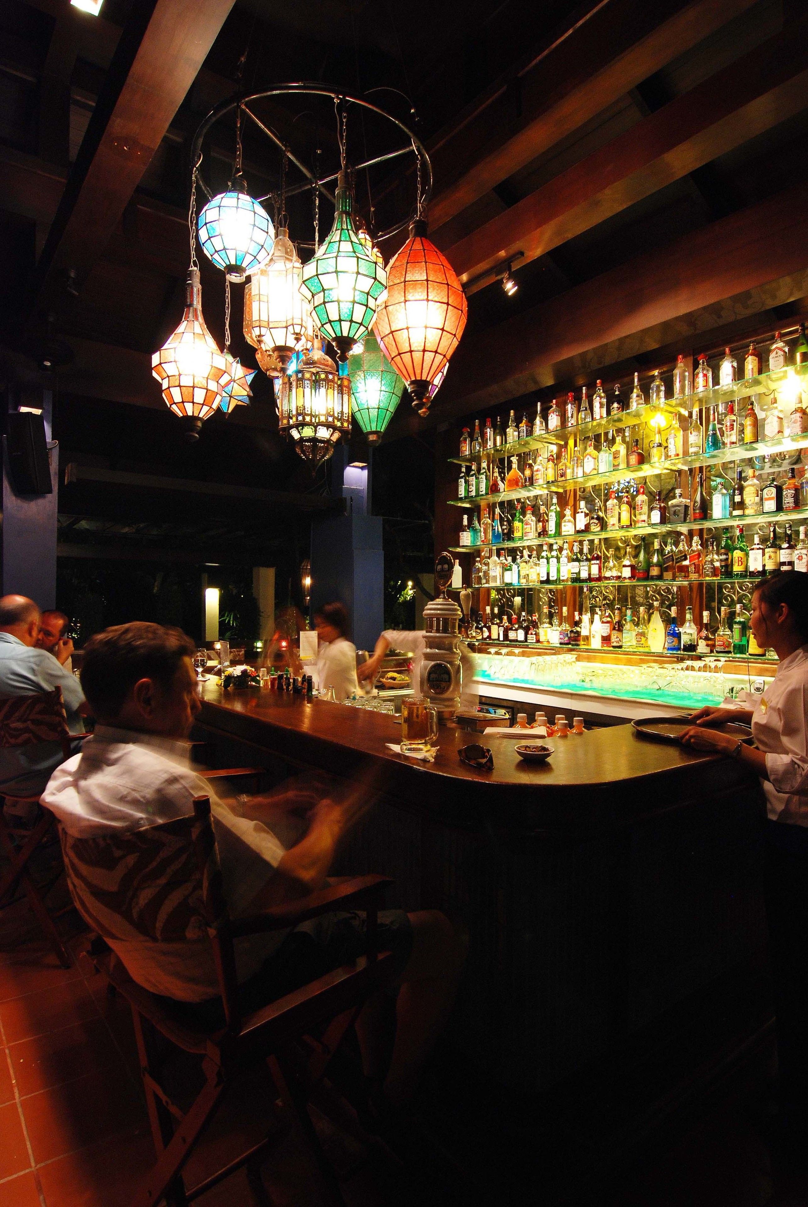 Un bar con faroles colgantes y una amplia selección de licores.