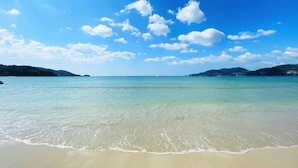 A beach with clear water, sandy shore, and distant hills. - Burasari Phuket Resort & Spa (Patong)