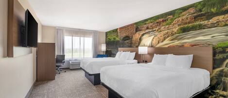 Ein Hotelzimmer mit zwei Betten, einem Fernseher, einem Schreibtisch und einem großen Wandbild eines Wasserfalls.