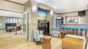 A hotel lobby with a fireplace, seating area, and a bar. - Clarion Pointe Sioux Falls Airport (Sioux Falls)