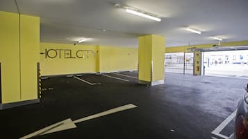 Een parkeergarage van een hotel met gele muren en een bord waarop 'HOTEL CITY' staat.