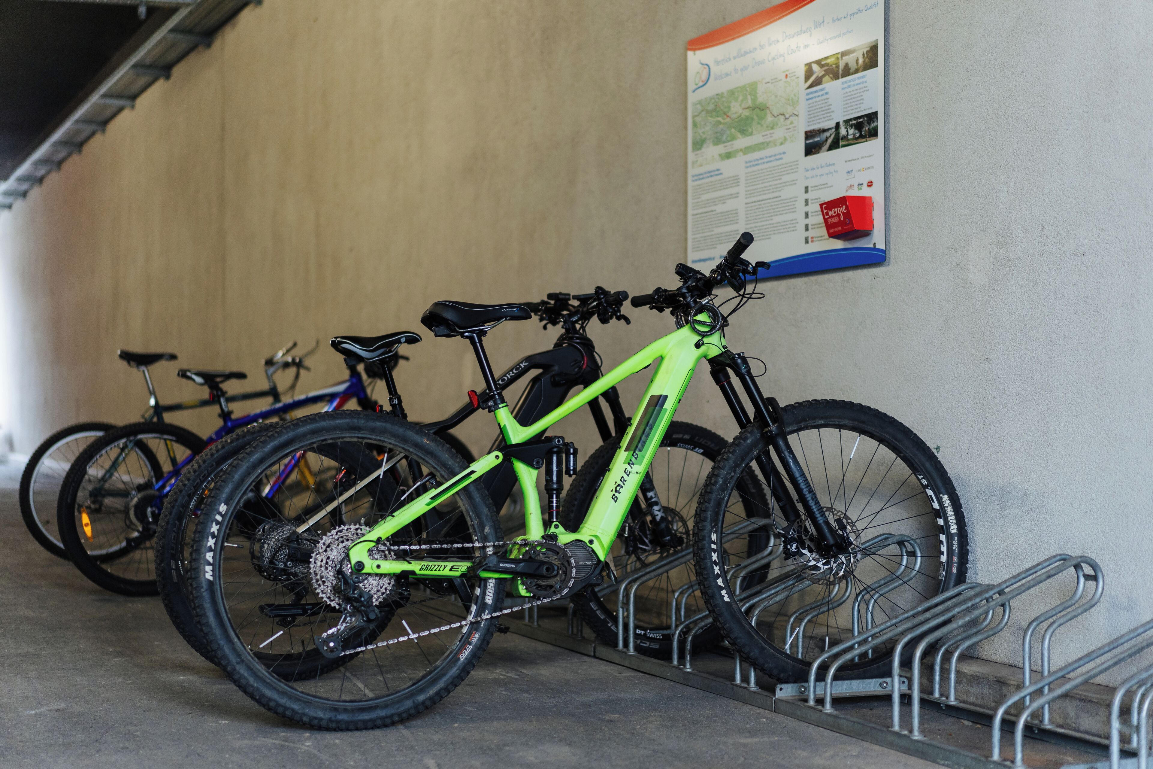 Un aparcamiento para bicicletas con un soporte y un mapa en la pared.