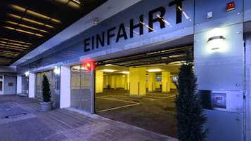 Une entrée d’immeuble avec le panneau « EINFAHRT » et l’intérieur d’un parking souterrain.