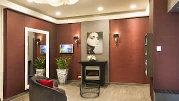Um lobby moderno com lareira, área de estar e arte decorativa na parede.