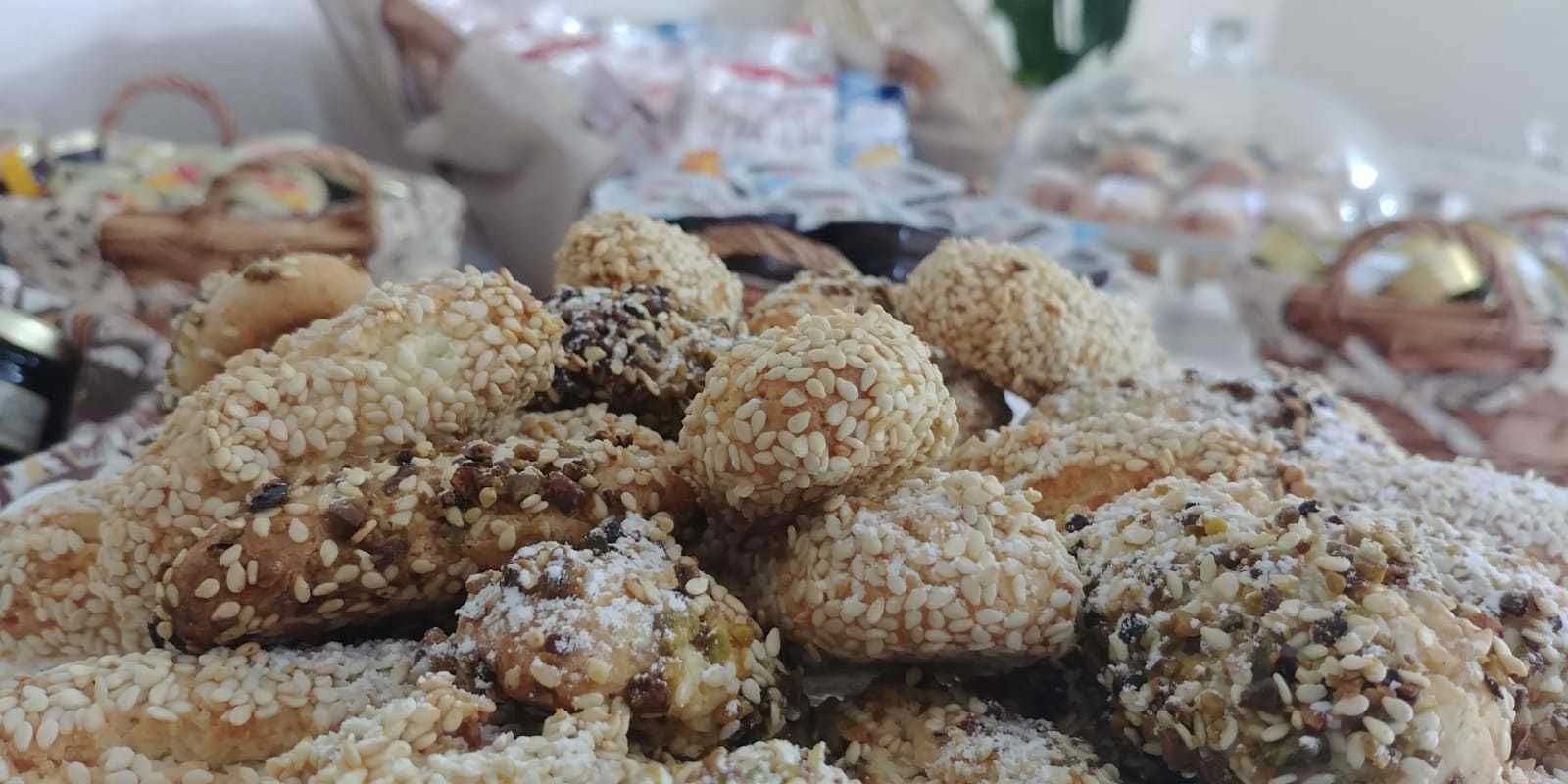 A variety of food items, including sesame-covered pastries and other baked goods.