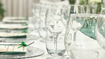 A table set with clear glassware and plates, with a green ribbon on one plate.