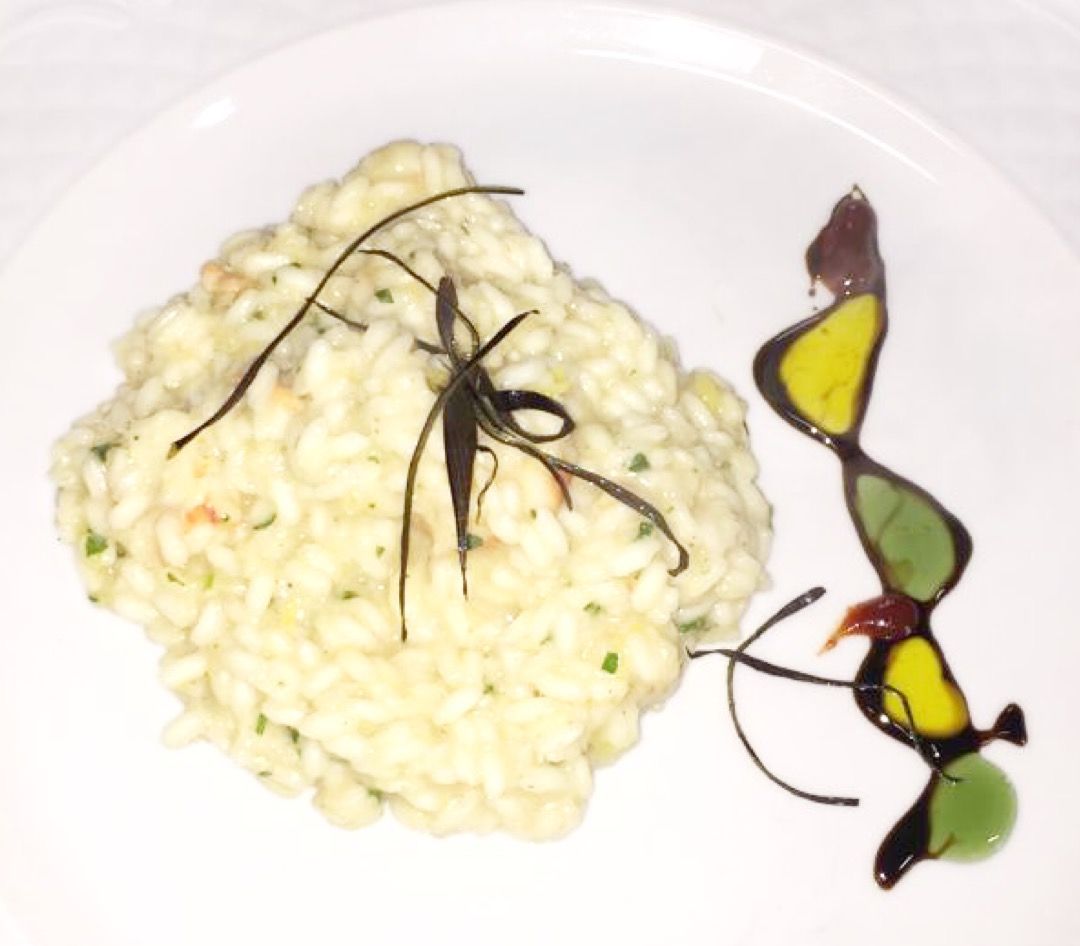 Prato de risoto com um inseto decorativo e molho.