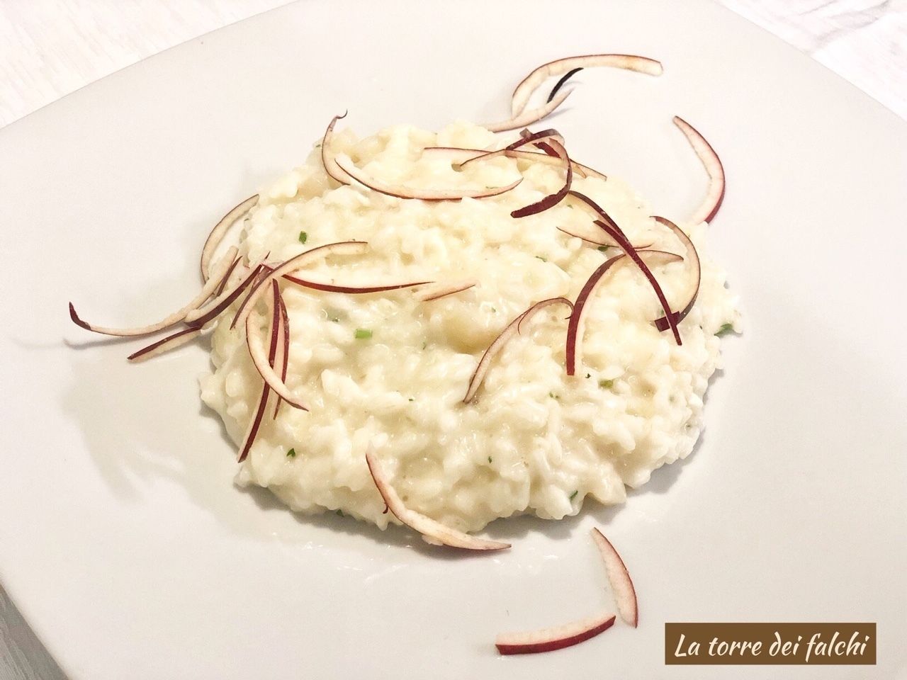 A plate of risotto with red onion garnish.
