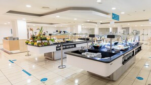 Zona de bufé con diversos alimentos y un piso limpio de baldosas.