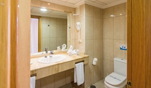 Une salle de bain équipée d’un lavabo, d’un miroir, d’un porte-serviettes et de toilettes.