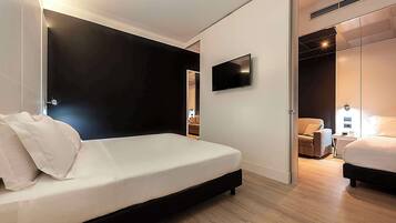 A modern bedroom with a bed, a TV mounted on the wall, and a walk-in closet.