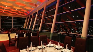 Un restaurante con un diseño moderno en el techo, ventanas amplias y una mesa lista para comer.