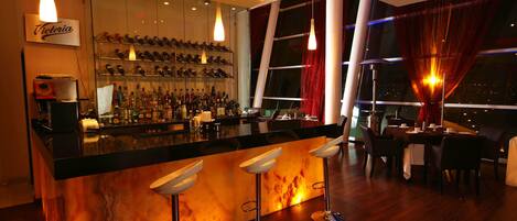 A bar area with a wine rack, bar stools, and a counter.