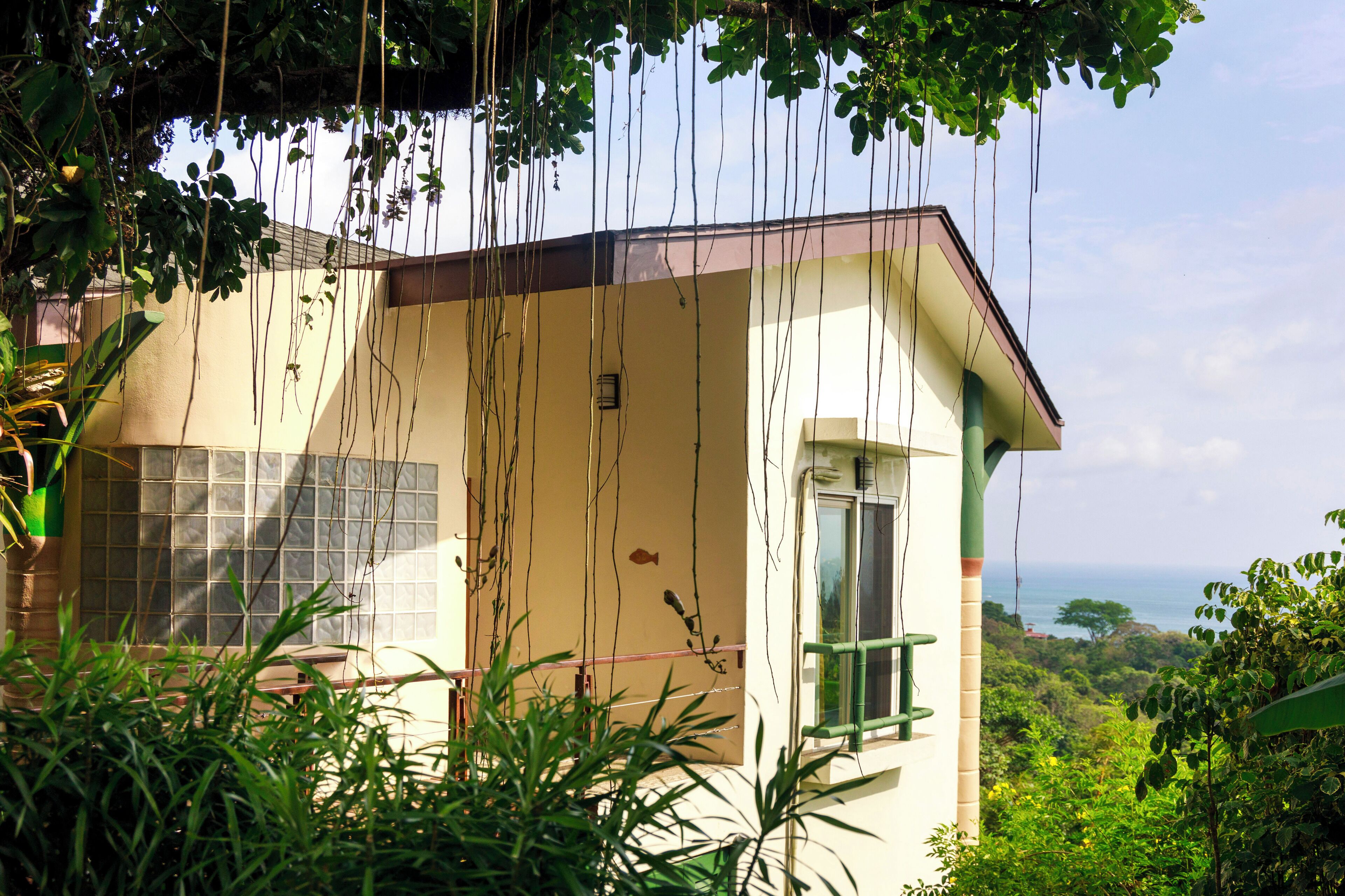 A house with a balcony overlooking a lush landscape.