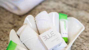 Una bandeja blanca con una toalla y dos tubos de loción corporal Blue Organics sobre una encimera de granito.