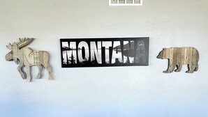 Een muur met drie houten dierenfiguren en een bord waarop de tekst 'MONTANA' staat.