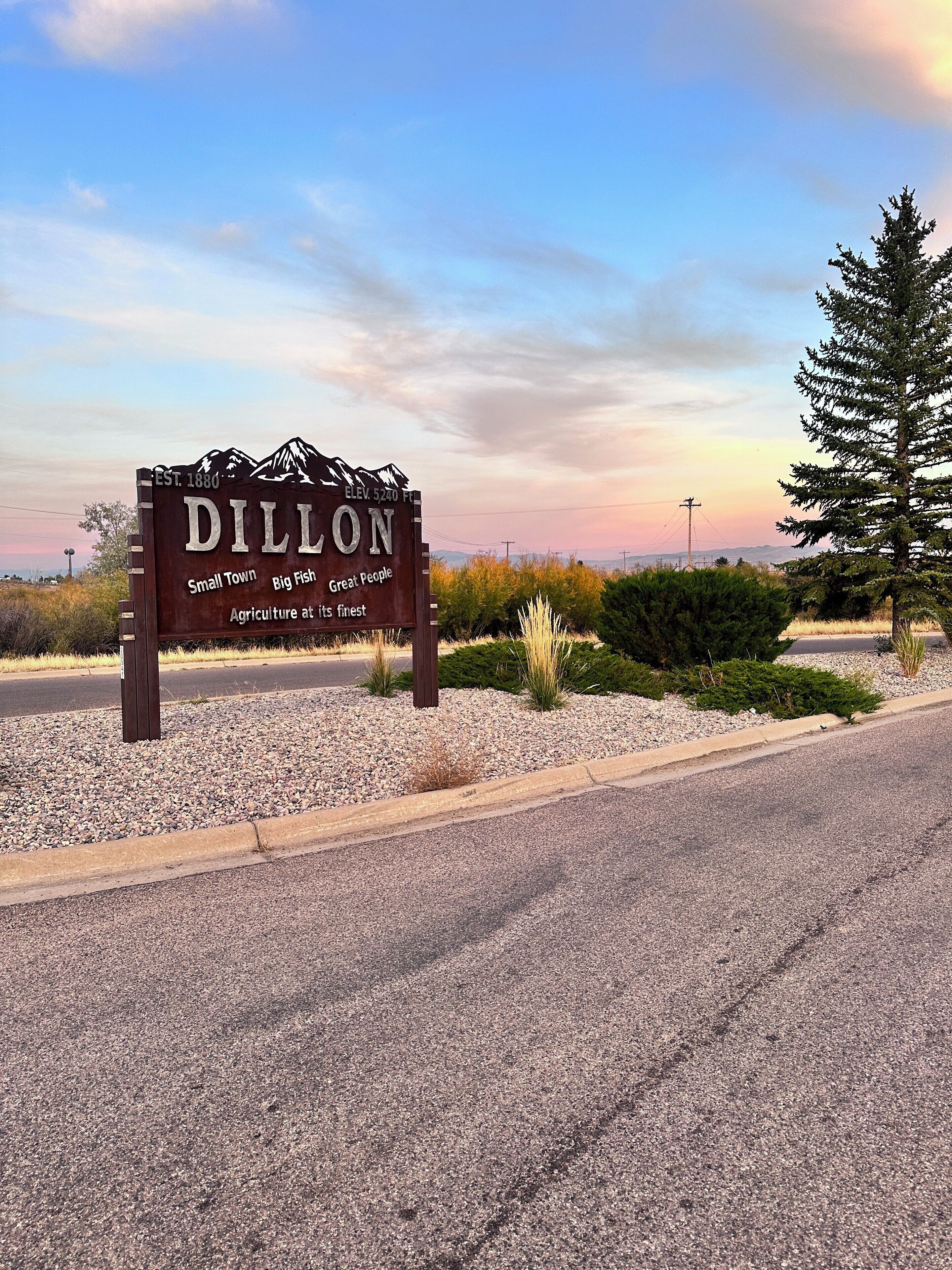 A sign for Dillon with a mountain silhouette, indicating elevation and a small-town feel.