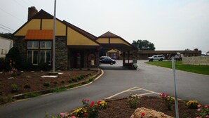 A building with a stone facade, a yellow roof, and an American flag.