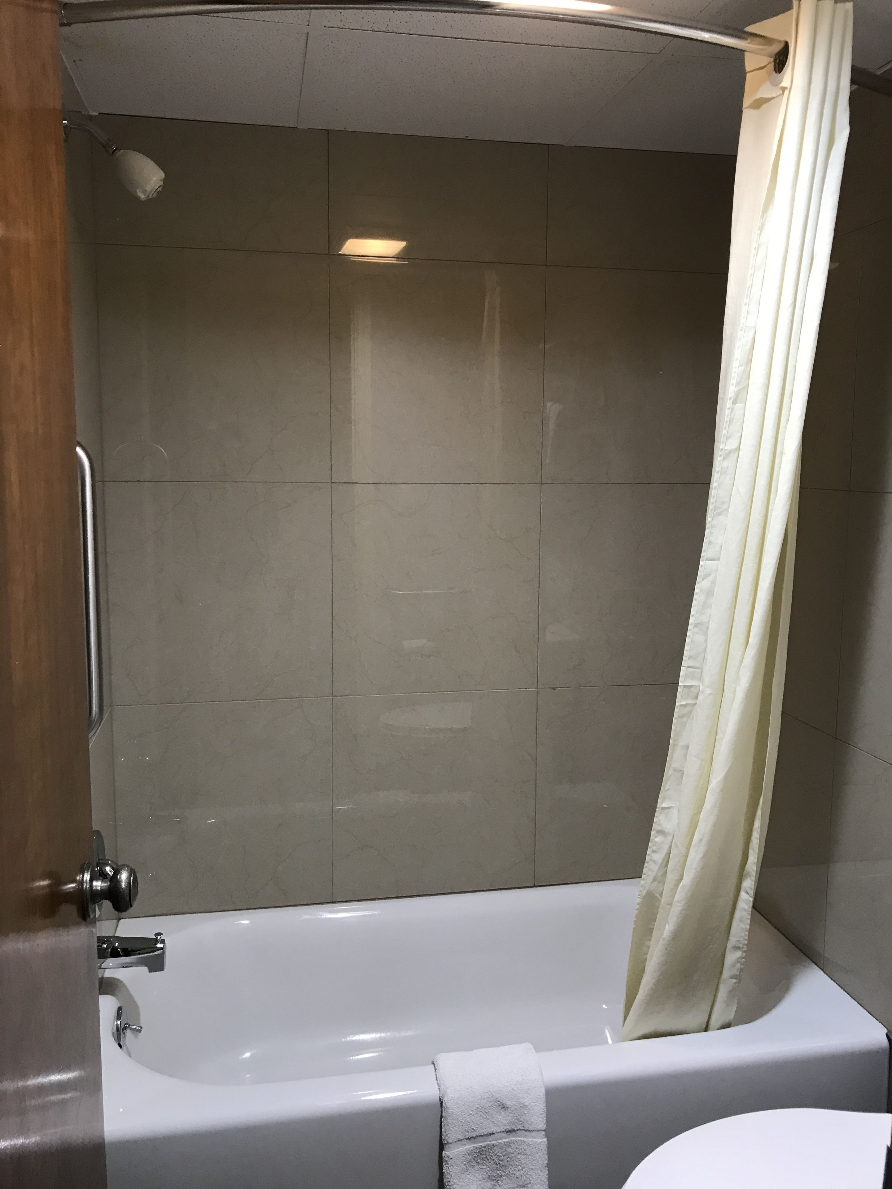 Ein Badezimmer mit Badewanne, Duschvorhang und Fliesen.