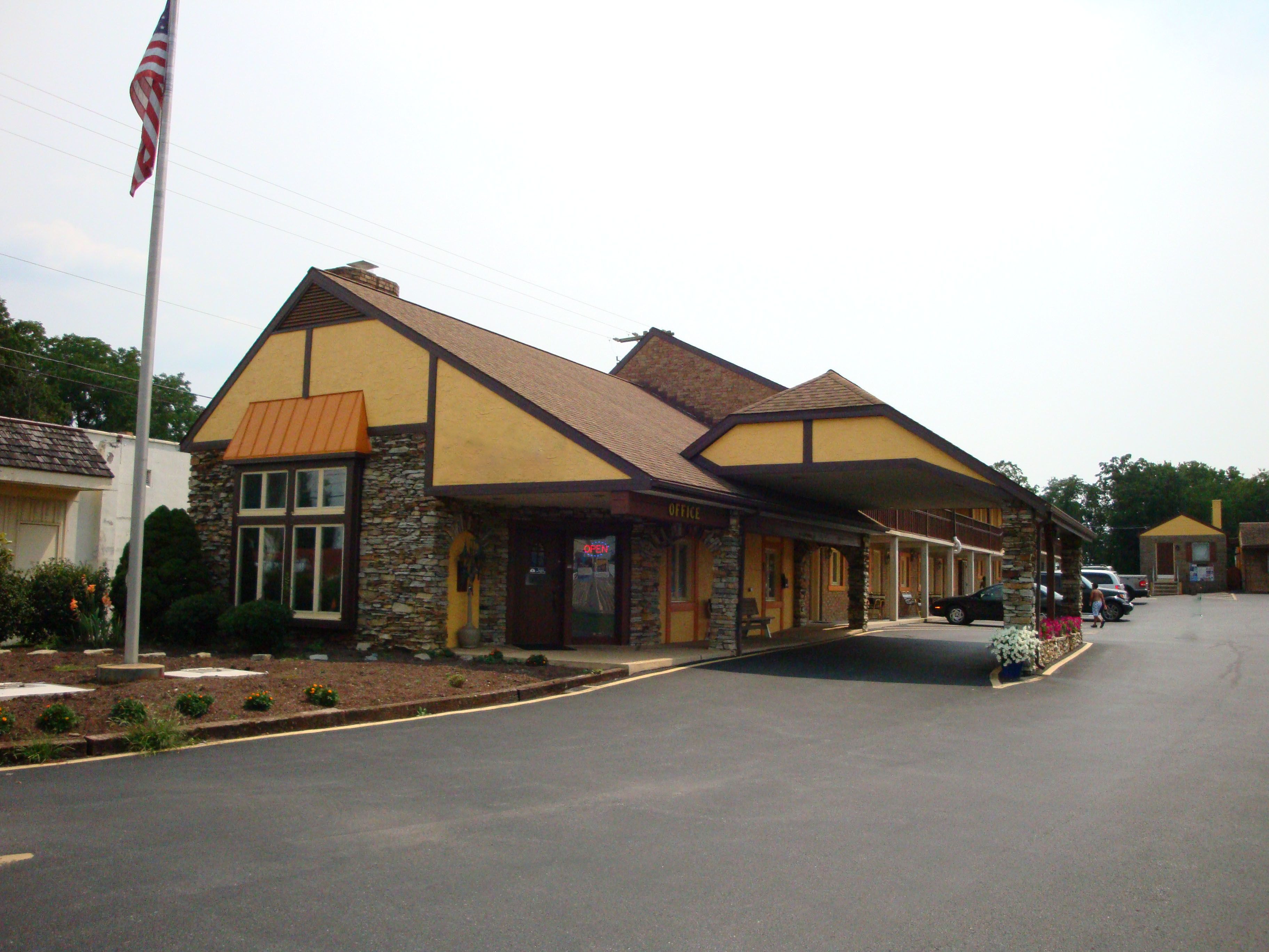 A two-story building with a stone facade and a yellow and brown roof.