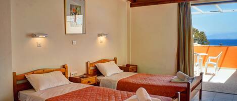 A hotel room with two beds, a painting on the wall, and a view of the sea through a window.