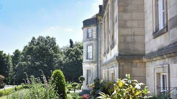 A historic building with a garden in front.