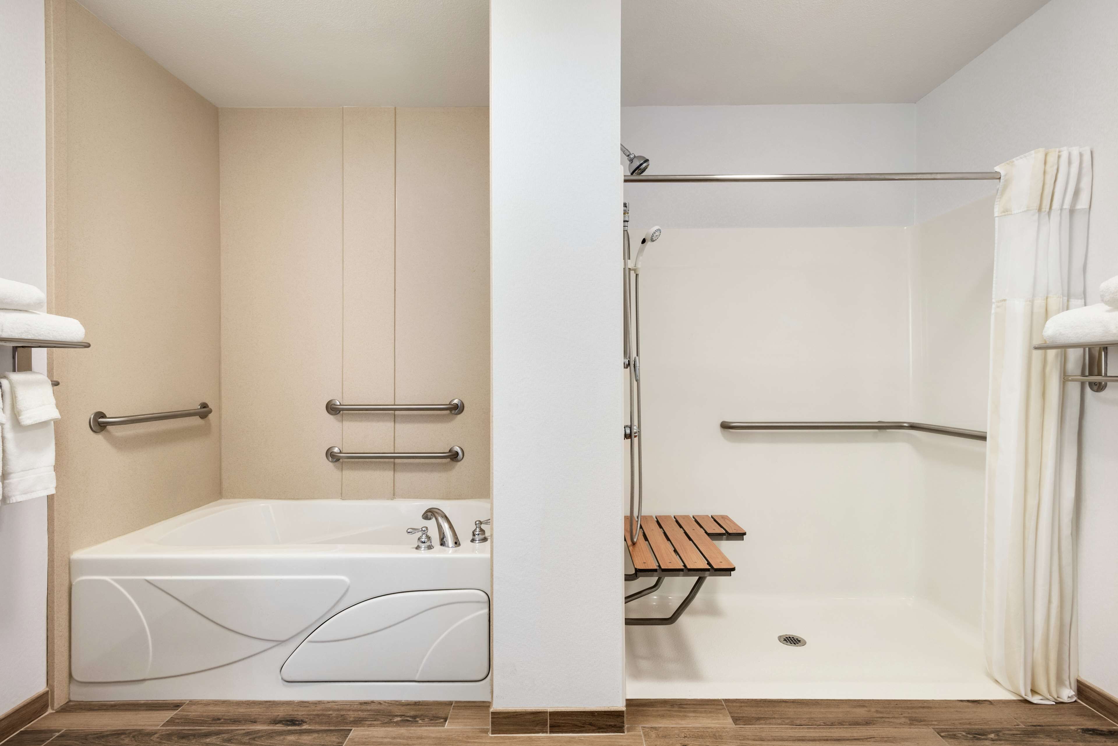 Un bagno moderno con vasca, doccia e una panca.