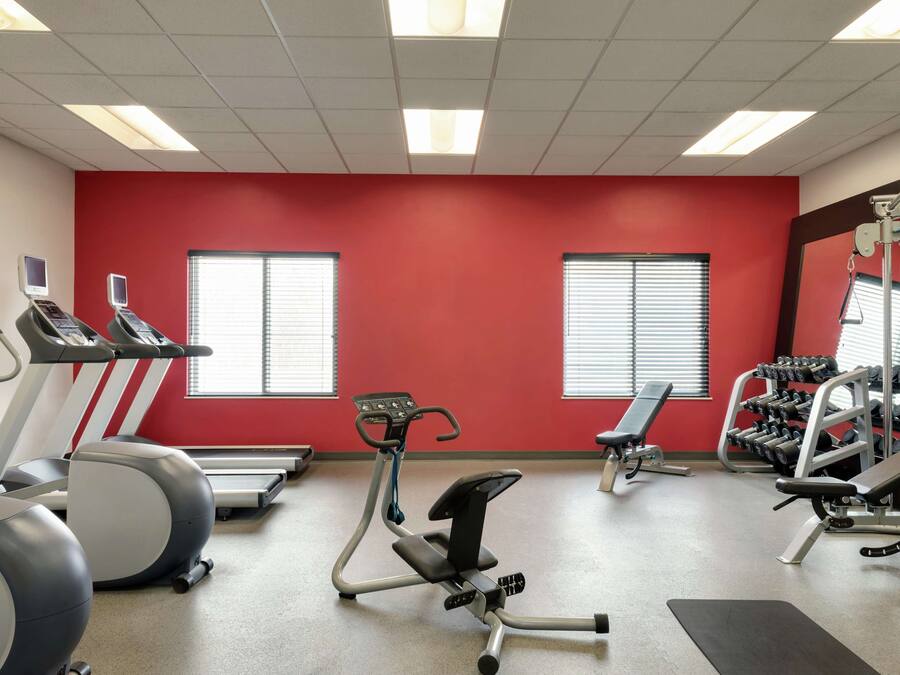 A gym with treadmills, an elliptical, benches, and weight machines.