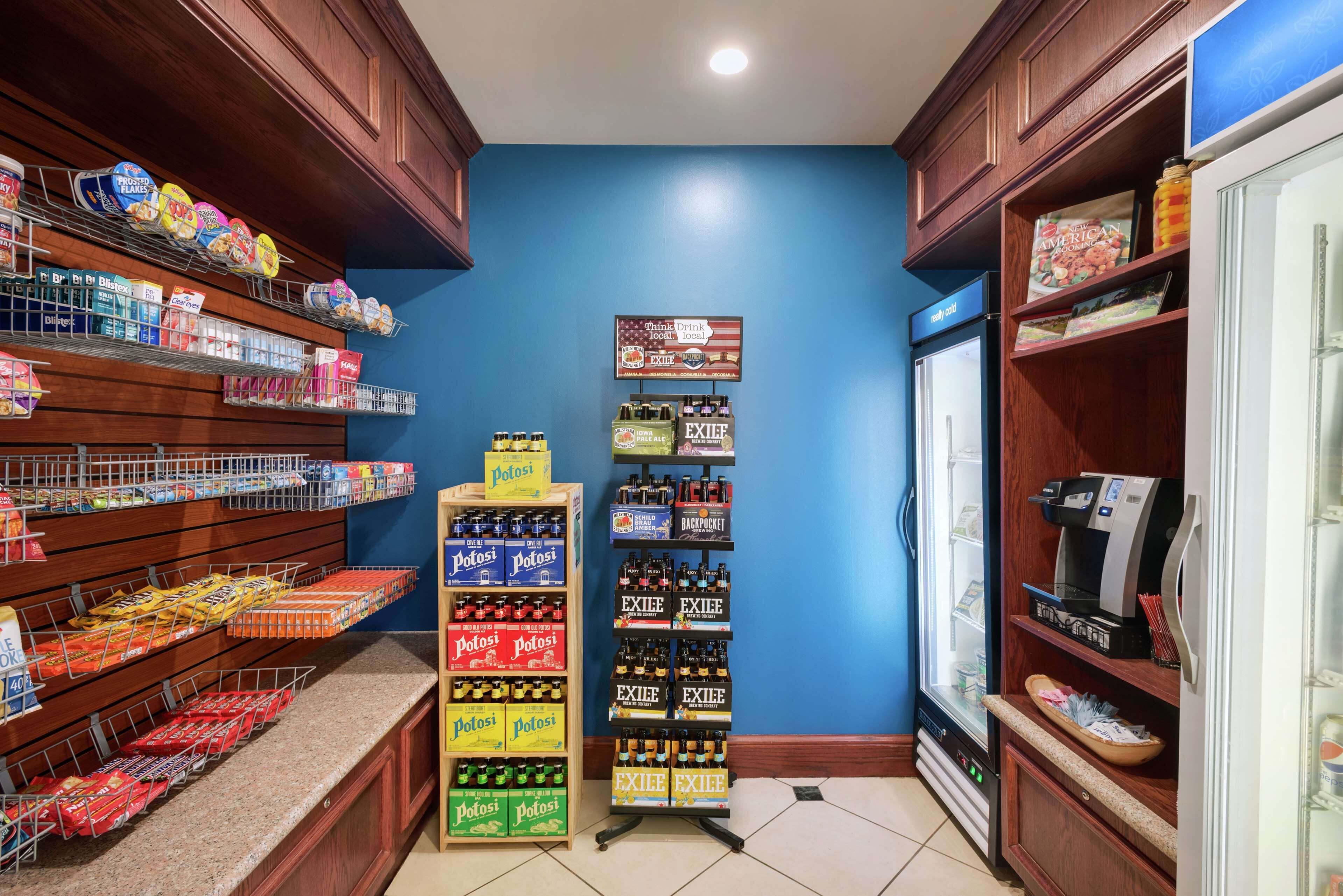 A grocery store with shelves stocked with various products, a refrigerated display case, and a self-serve beverage station.