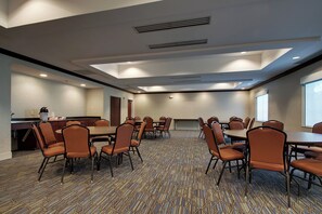 A conference room with multiple tables and chairs, a kitchenette, and a patterned carpet. - Holiday Inn Express Hotel & Suites Middleboro Raynham by IHG (Middleborough)