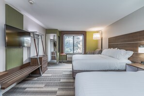 A hotel room with two beds, a TV, a desk, and a window with a view of trees. - Holiday Inn Express Hotel & Suites South Bend by IHG (South Bend)