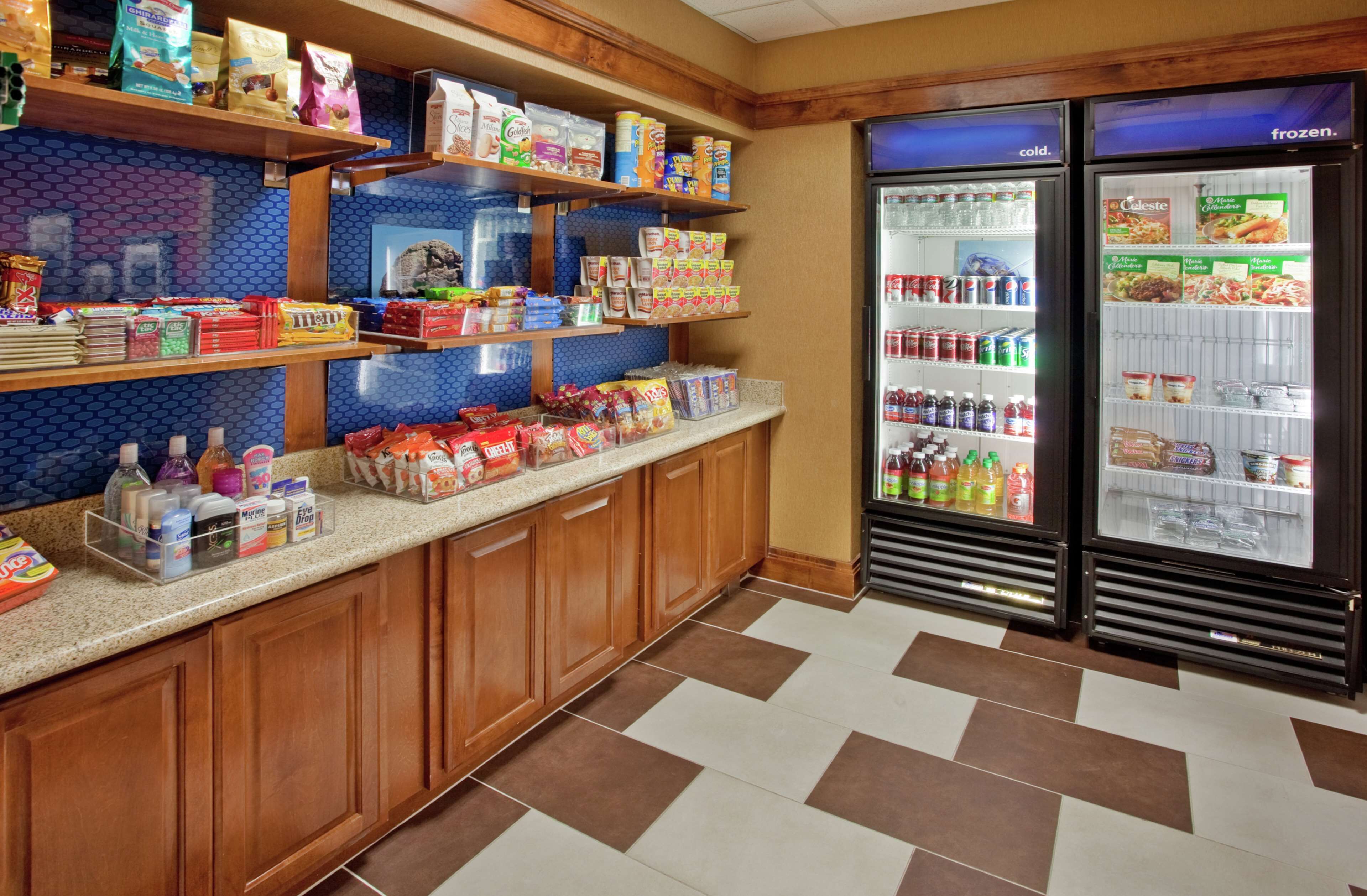A self-service breakfast area with shelves stocked with cereals, snacks, and beverages.