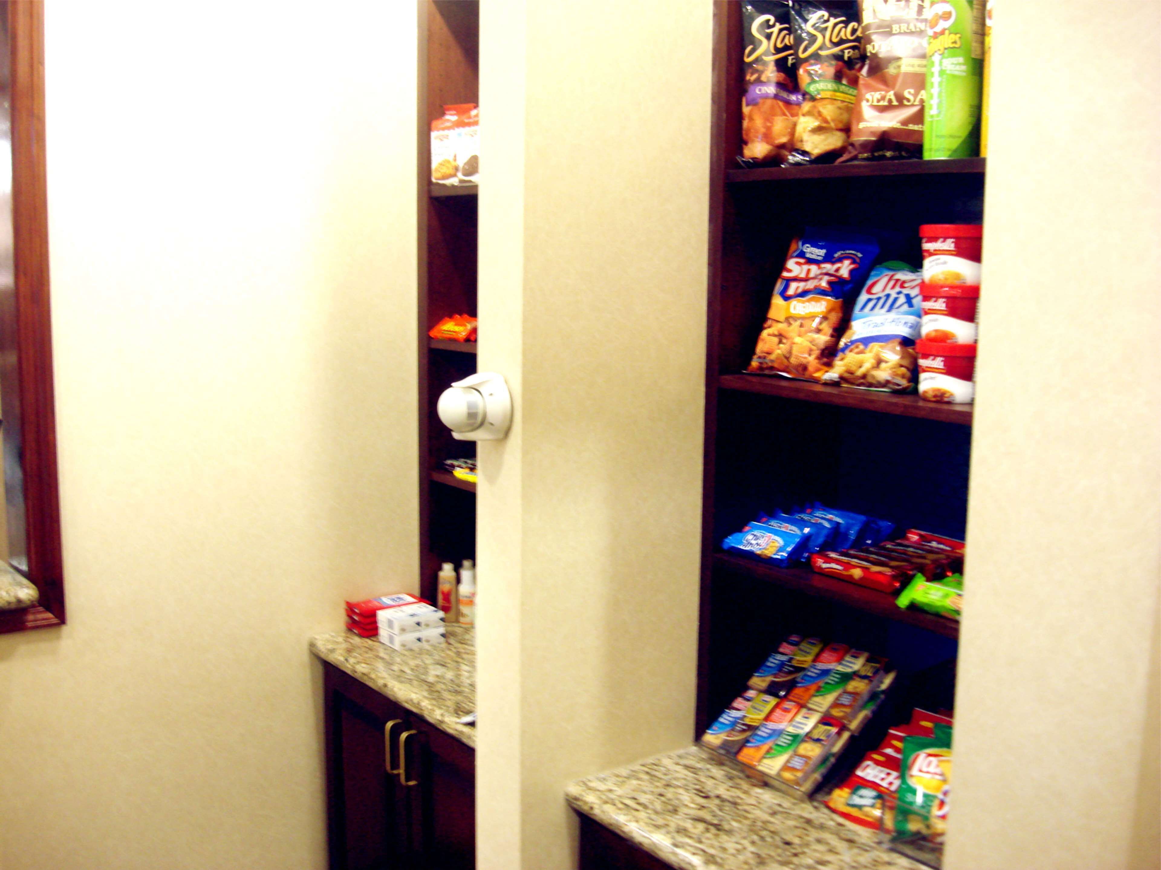 A pantry with shelves stocked with snacks, beverages, and baking supplies.