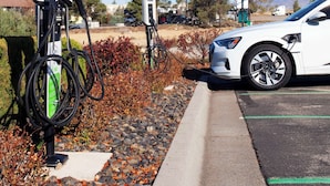 A parking area with electric vehicle charging stations, a white car parked, and a clear blue sky. - Hampton Inn & Suites Mountain Home (Mountain Home)