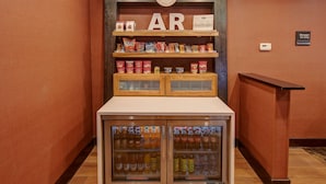 Un présentoir proposant diverses confiseries et boissons emballées, installé dans le hall d’un hôtel.