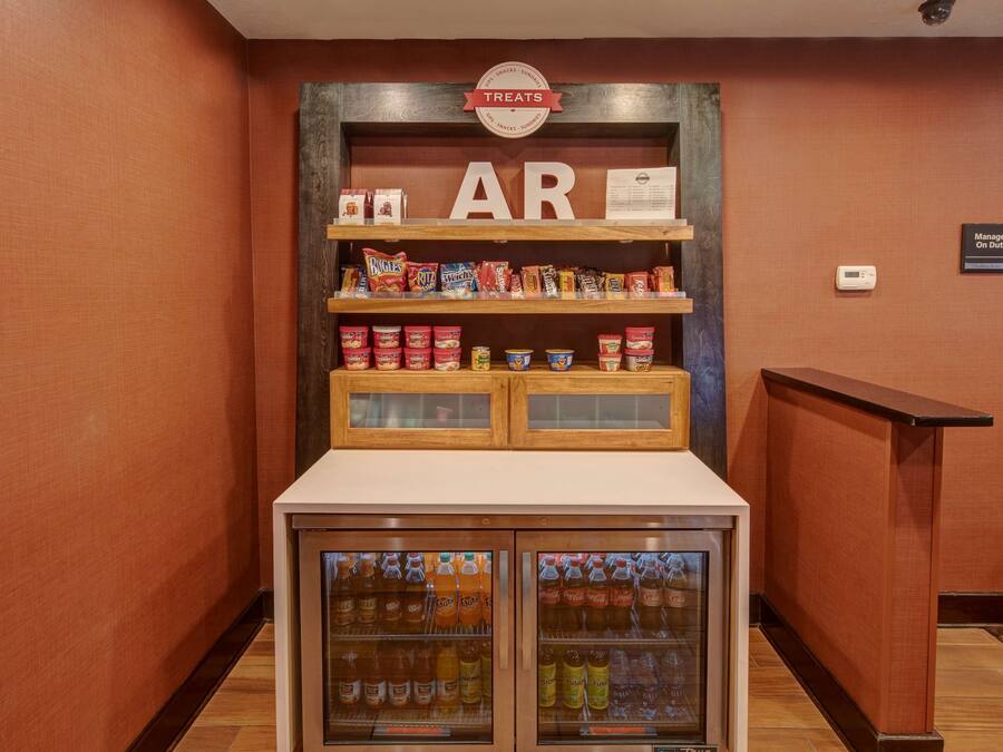 A snack display with various packaged treats and beverages in a hotel lobby.