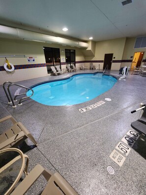 A swimming pool with lounge chairs, a lifebuoy, and a sign indicating a 4ft depth.