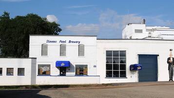 A white building with the sign "Stevens Point Brewery" and a blue awning.