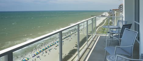En balkon med udsigt over en strand og hav.