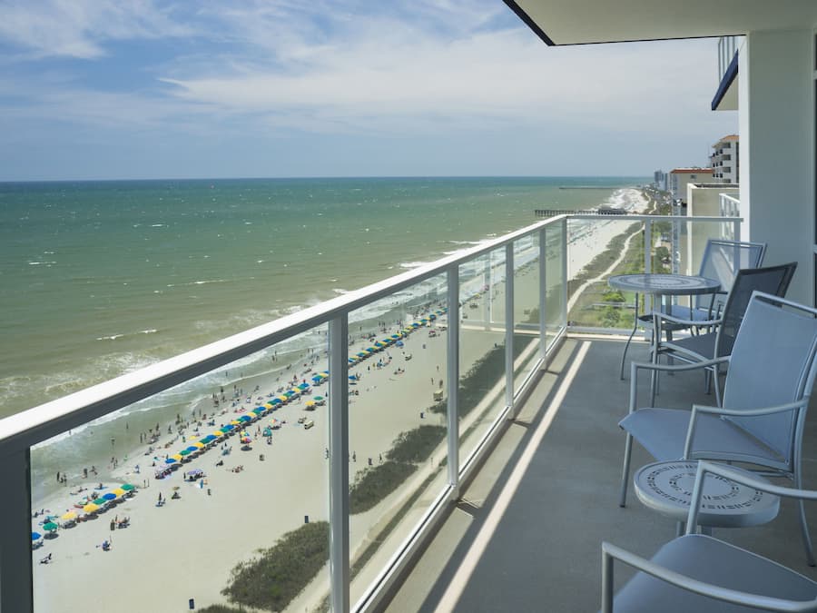 A balcony with a view of a beach and ocean.