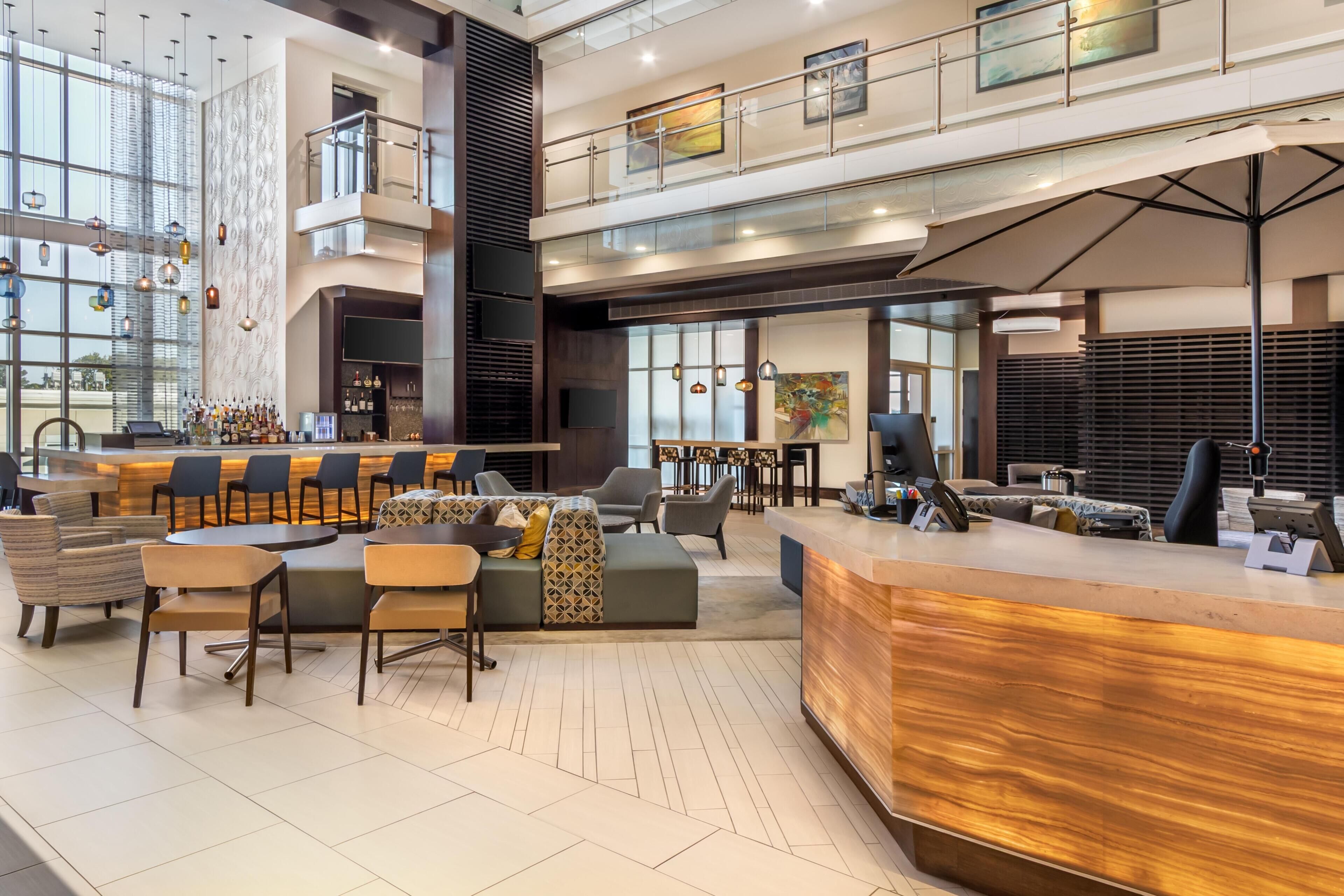 Eine geräumige Lobby mit einer Rezeption, einer Sitzecke und einer Bar.