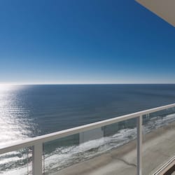 Enjoy the serene ocean views from this balcony with a clear view of the sandy beach.