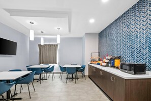 A modern kitchen with a microwave, toaster, and fruit bowl on the counter.