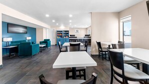Un restaurante moderno con diversas opciones de asientos, incluyendo mesas, sillas y una barra. Se observa un letrero que dice 'Quality'.