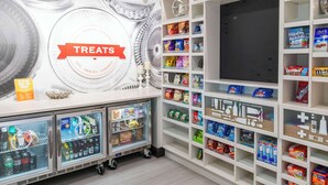 A treats section with a variety of snacks and beverages, including a refrigerated display and shelves stocked with items like Welch's and Bonde. - Hampton Inn & Suites Effingham (Effingham)