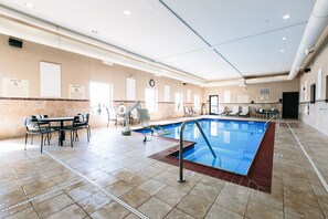 Una piscina techada, sillones reclinables de piscina