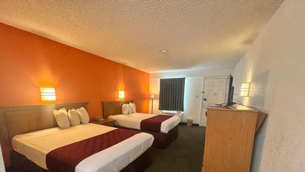 A hotel room with two beds, a desk, and a chair. - Delta Inn West Helena US 49 AR (West Helena)