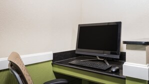 Een computerbureau met een monitor, toetsenbord en muis.