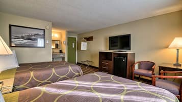 A hotel room with two beds, a television, a desk, a chair, and a painting on the wall.